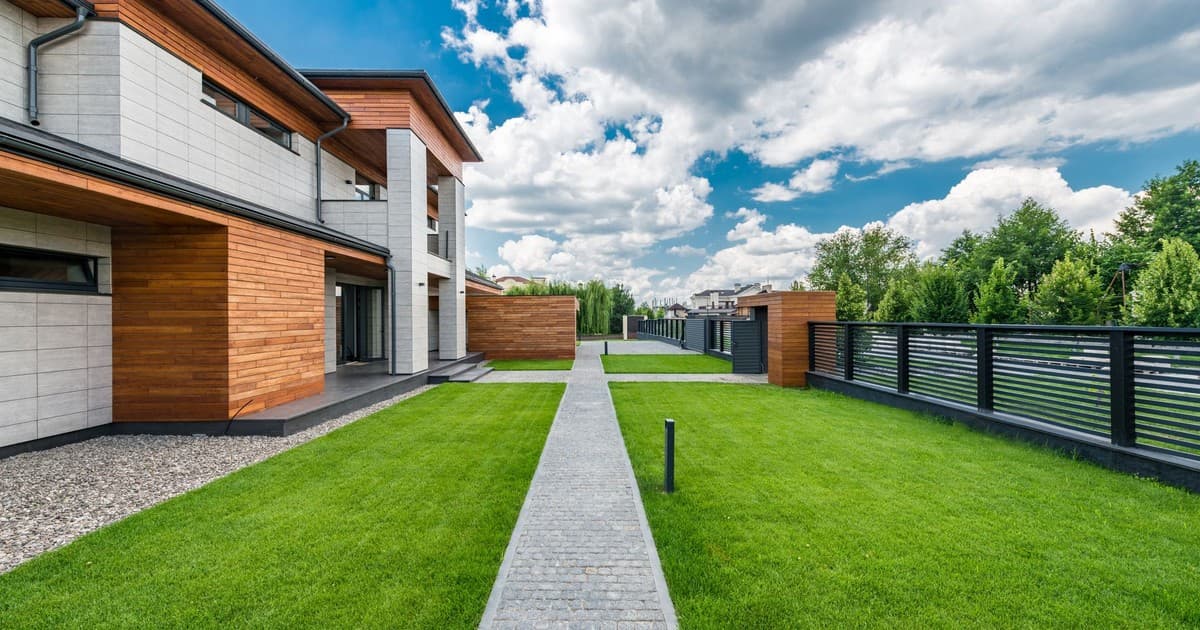 Modern house with a green lawn, representing a DHA Lahore residential plot ready for transfer