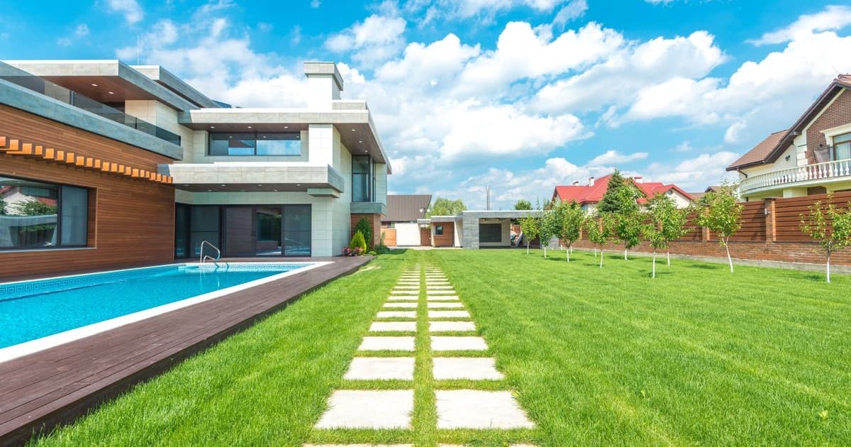 Modern villa with lawn and swimming pool, typical of developed DHA housing sectors in Lahore