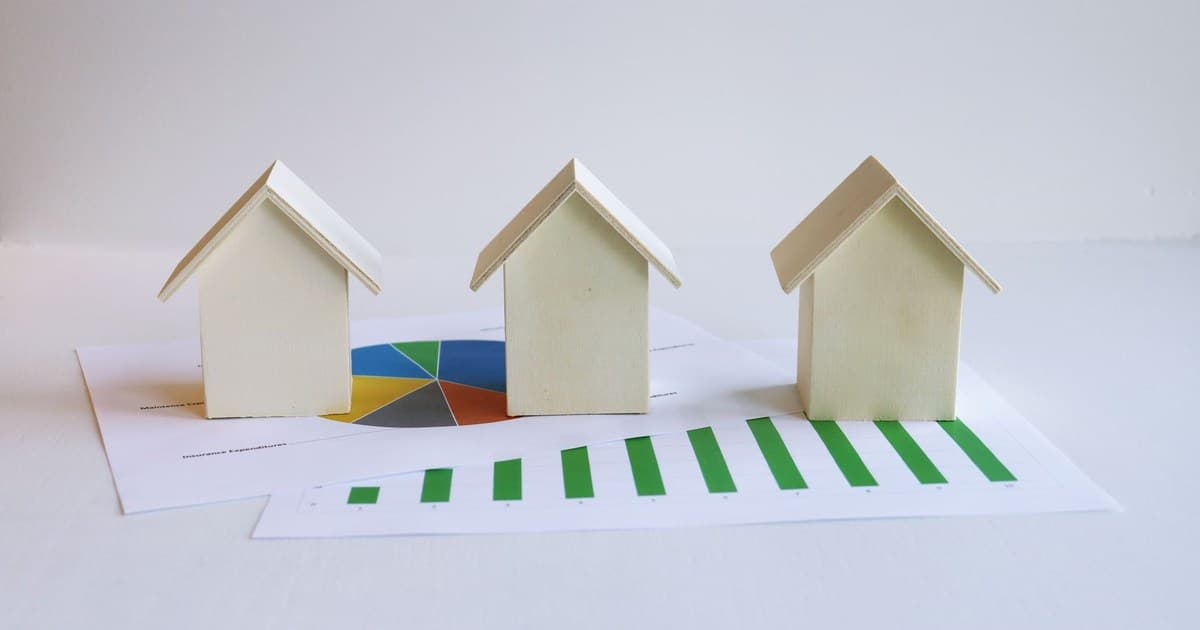 Wooden model houses on printed charts representing property valuation