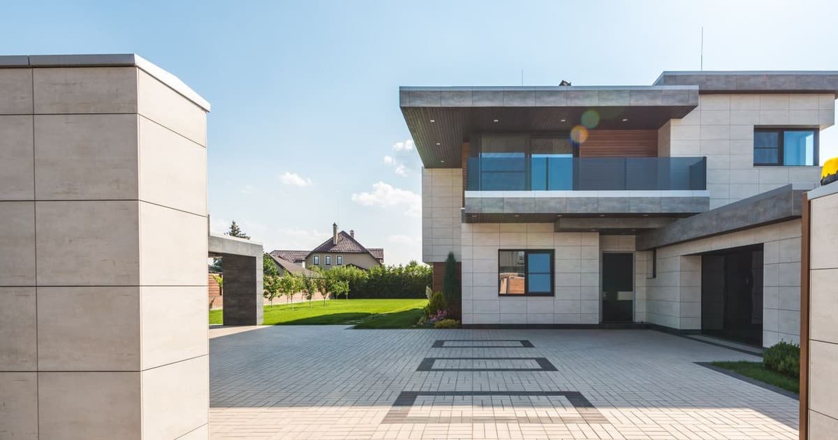 A modern two storey house with a paved driveway and green lawn, ready for a buyer viewing
