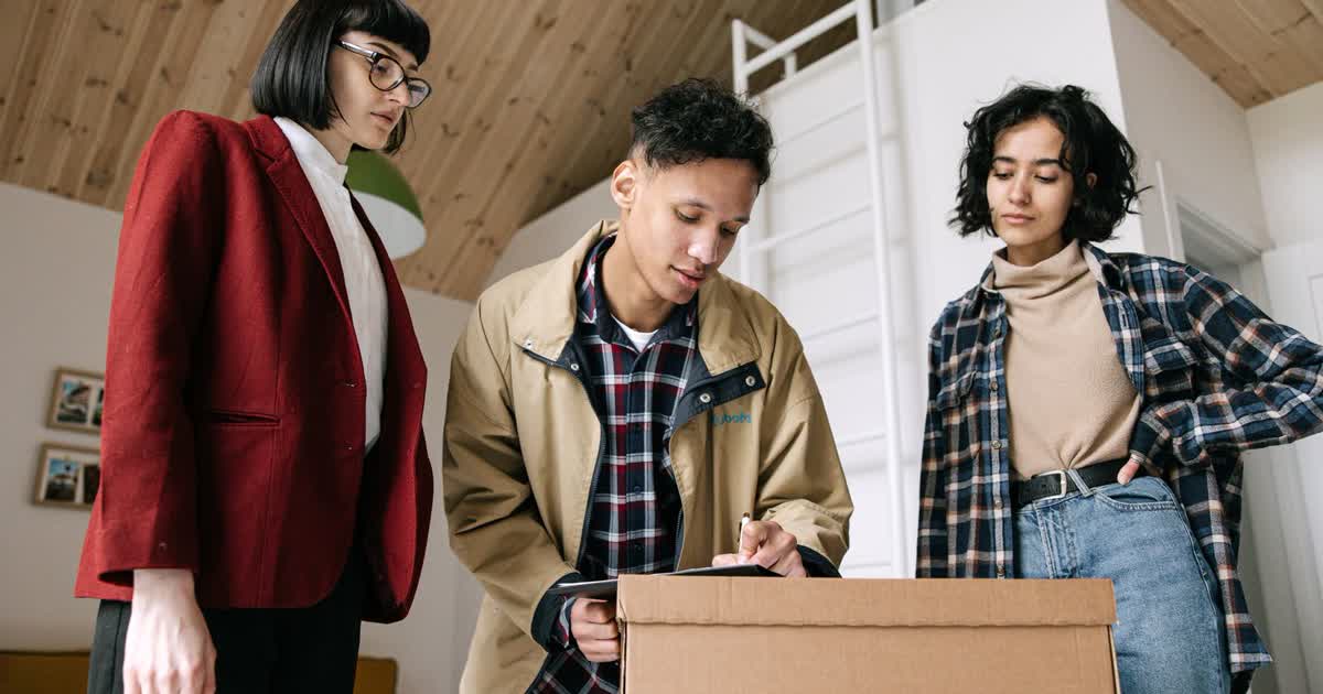 Property buyers signing booking documents with a real estate agent