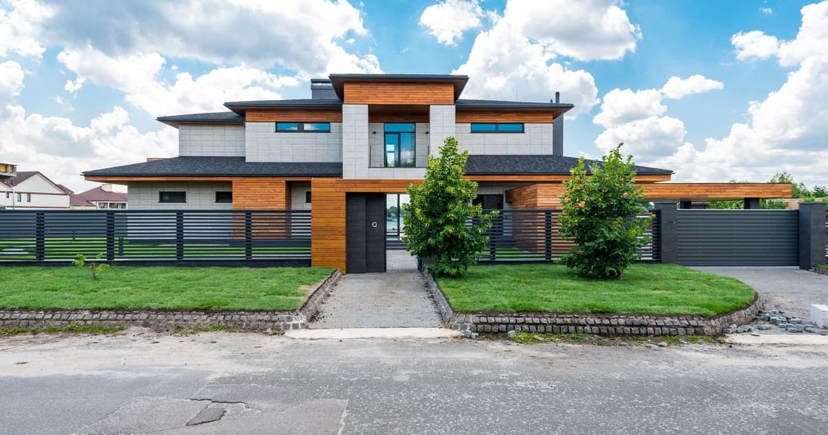 Modern house with lawn and boundary fence in a developed residential neighbourhood