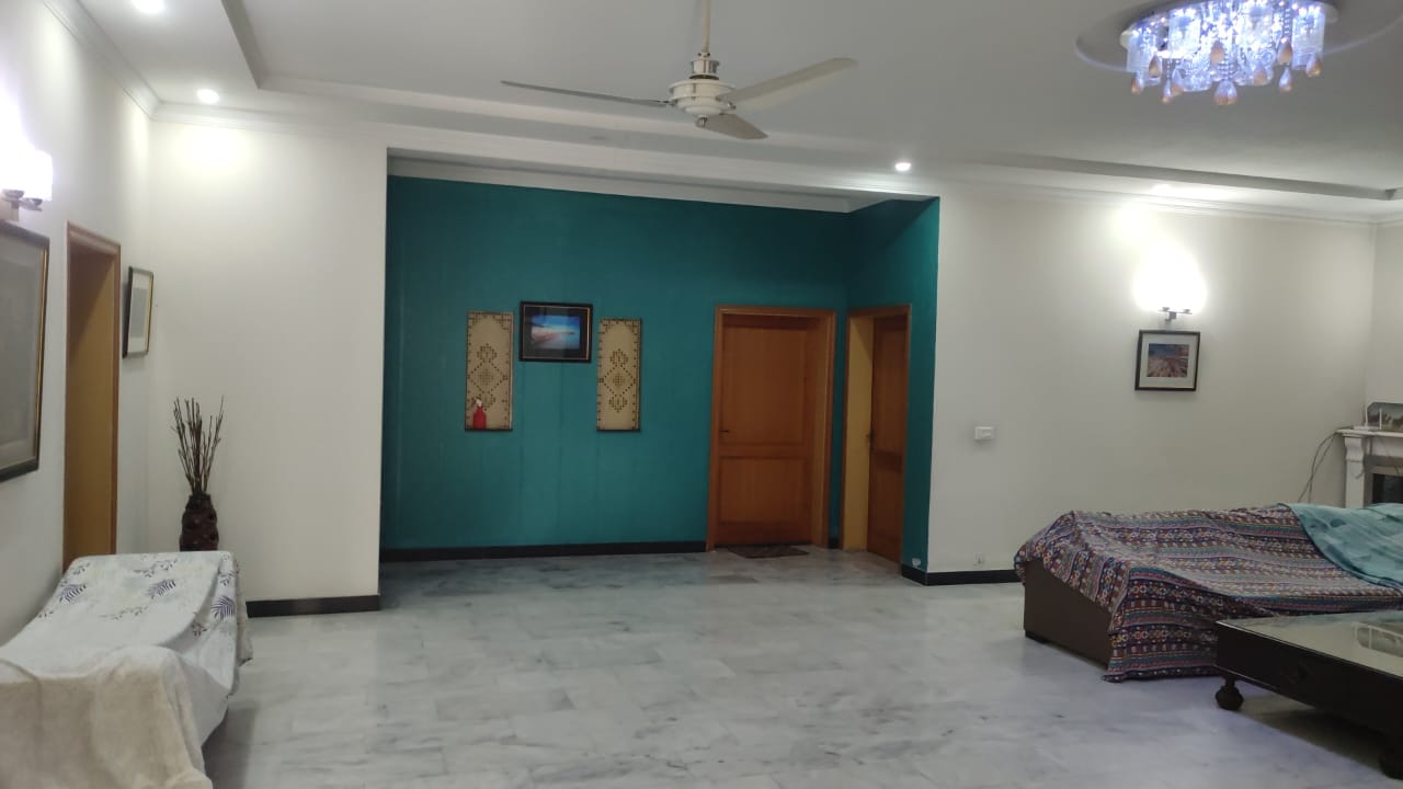 Drawing room with teal accent wall and marble flooring