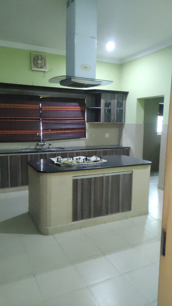 Kitchen with island, wooden cabinets and range hood